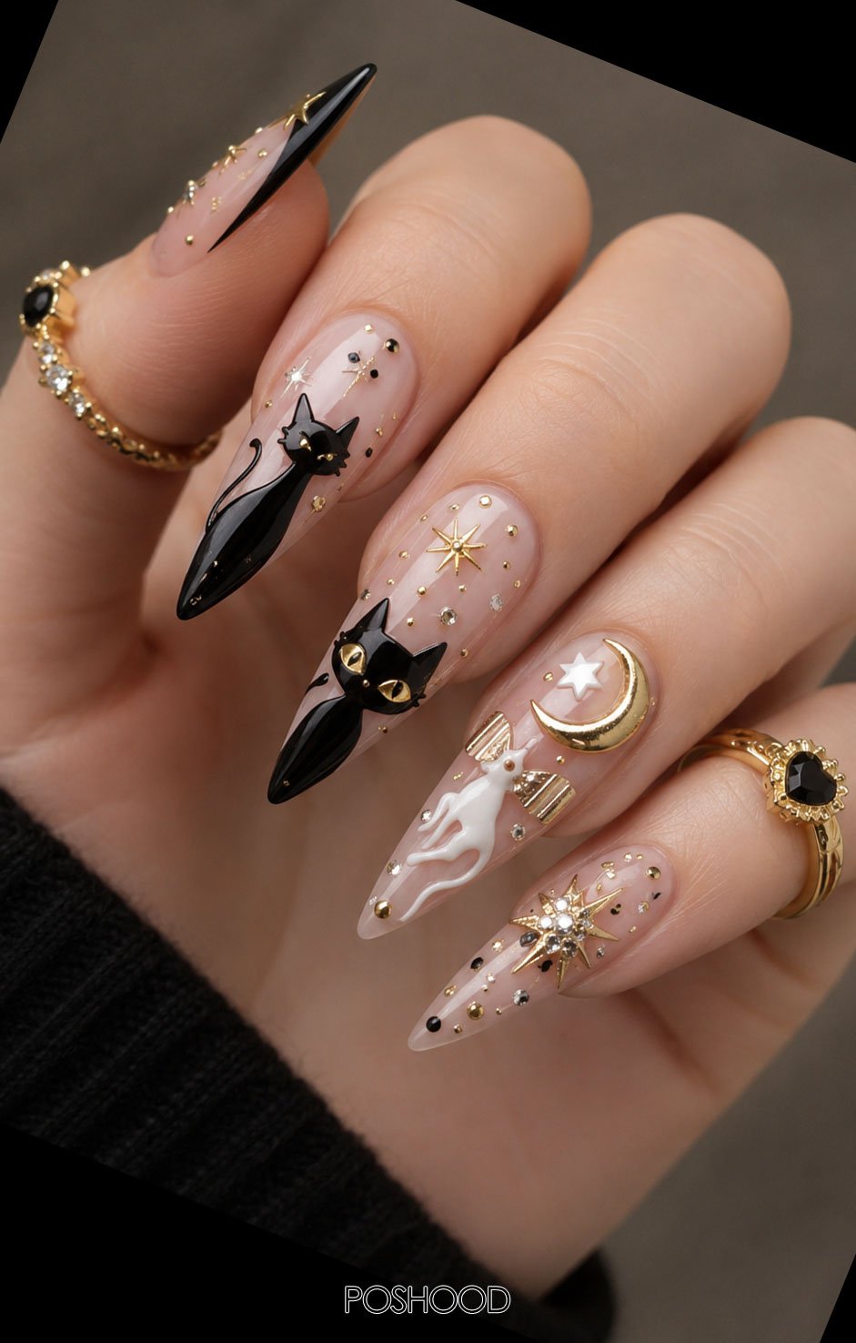Glossy nude almond nails featuring adorable black cat faces, golden stars, and crescent moon accents with silver rings.