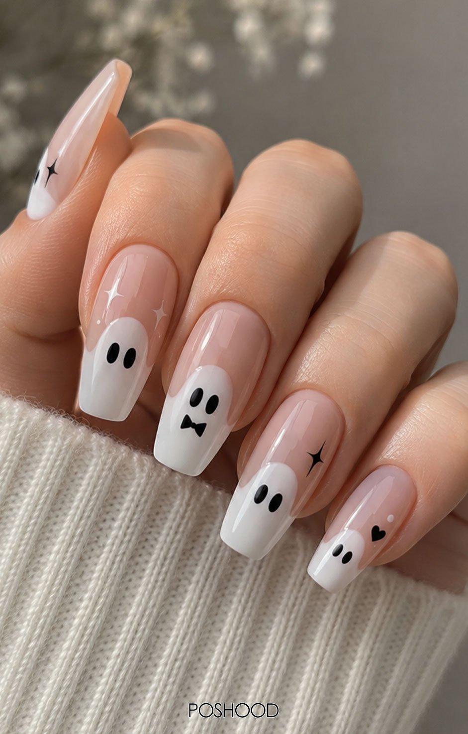 Glossy pink almond-shaped French tip nails featuring adorable white ghosts with tiny black eyes and silver rings.