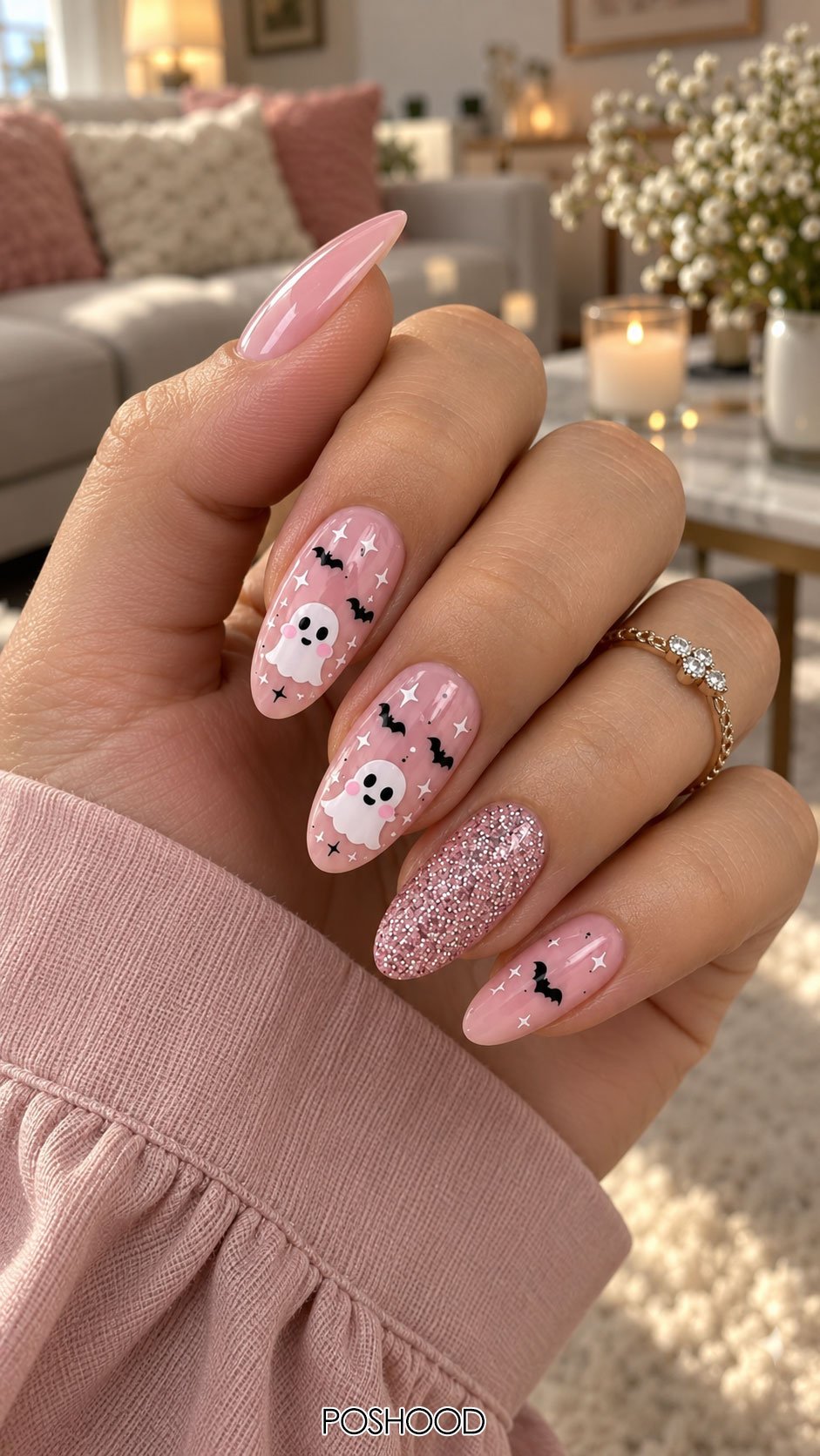 Cute Halloween nails ideas with pink ghost and black bat nail art, glitter accent nail, and glossy almond-shaped nails.