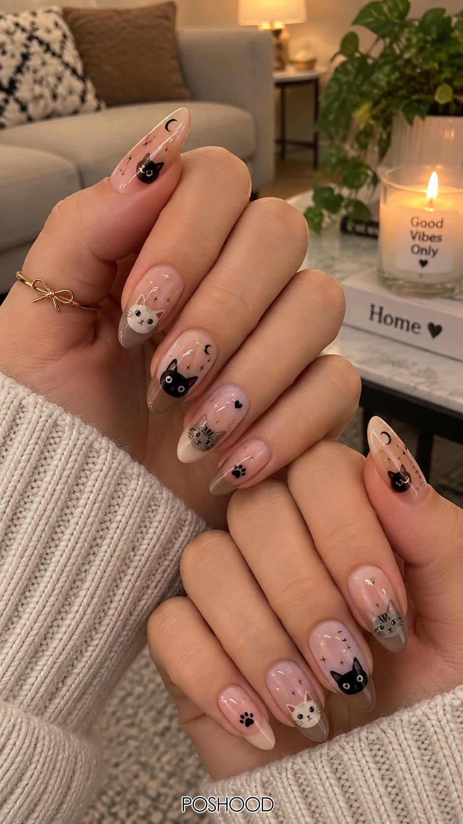 Cute Halloween nails ideas with black and gray cat faces, crescent moons, stars, and paw print details on almond-shaped nails.