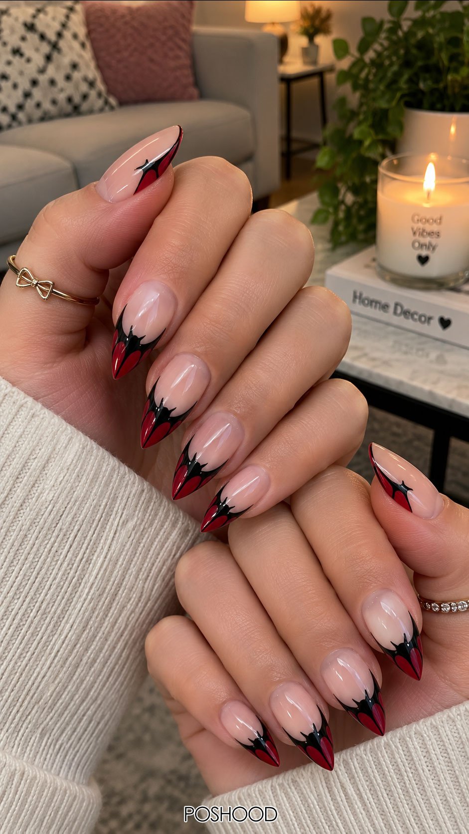 Cute Halloween nails ideas featuring red and black vampire-inspired French tips with sharp almond-shaped nails.