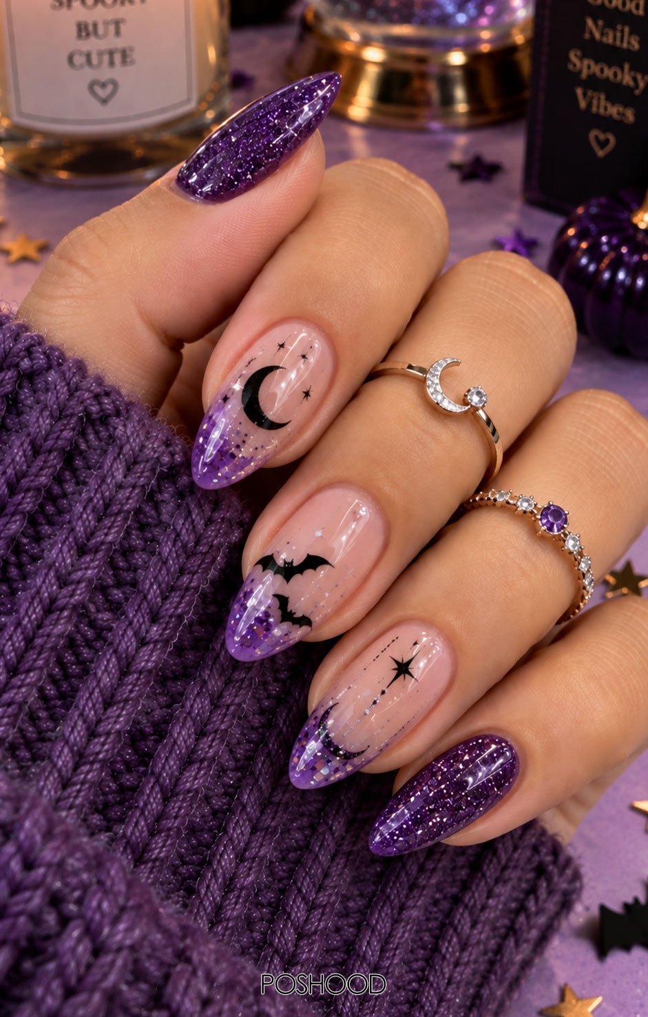 Sparkling purple almond-shaped Halloween nails featuring fine glitter, crescent moons, tiny black bats, stars, and holographic accents, styled with cozy purple knitwear and delicate rings.