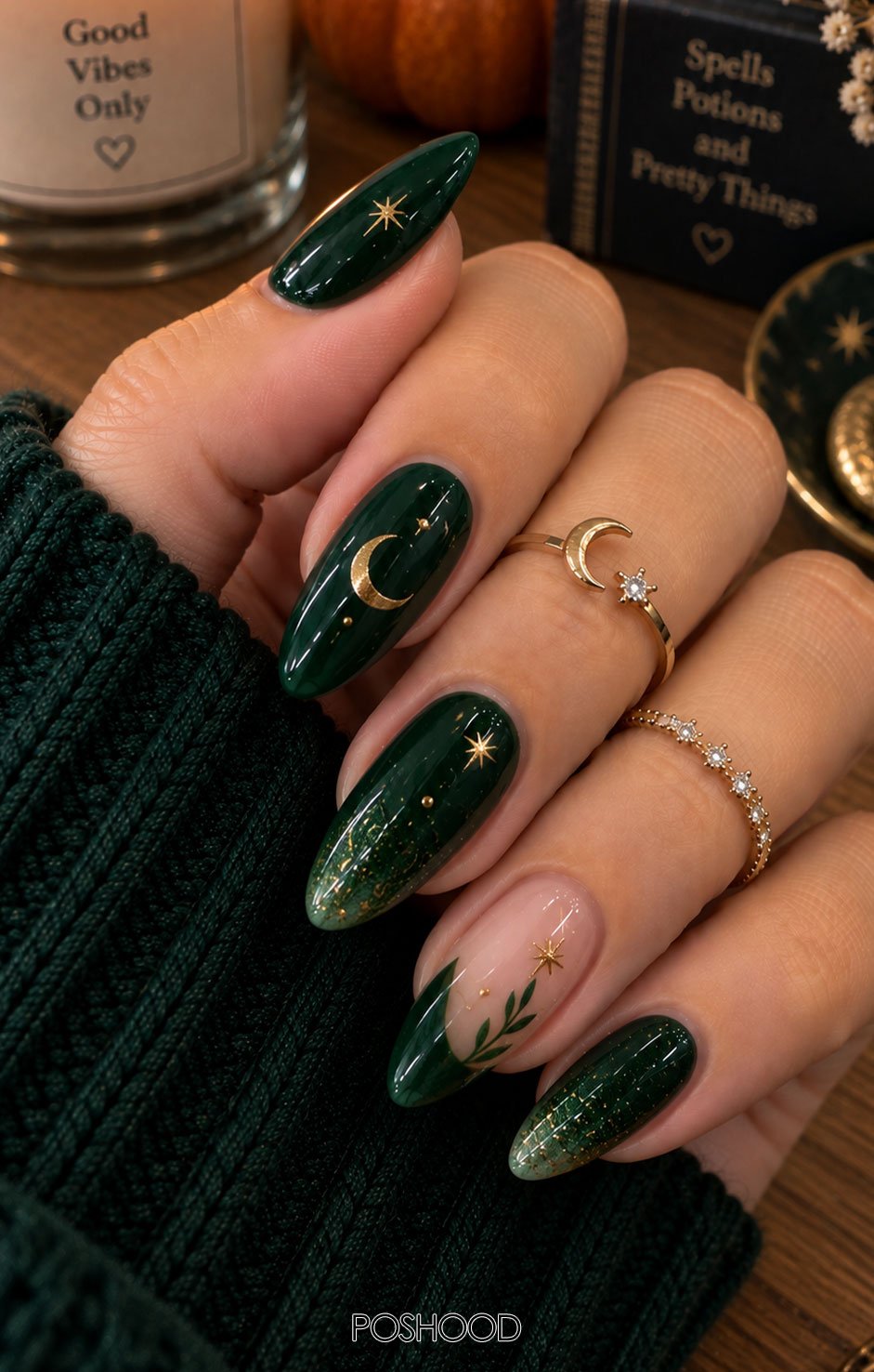 Glossy emerald green almond-shaped Halloween nails decorated with tiny potion bottles, bubbling cauldrons, golden stars, and magical sparkles against a natural autumn background.