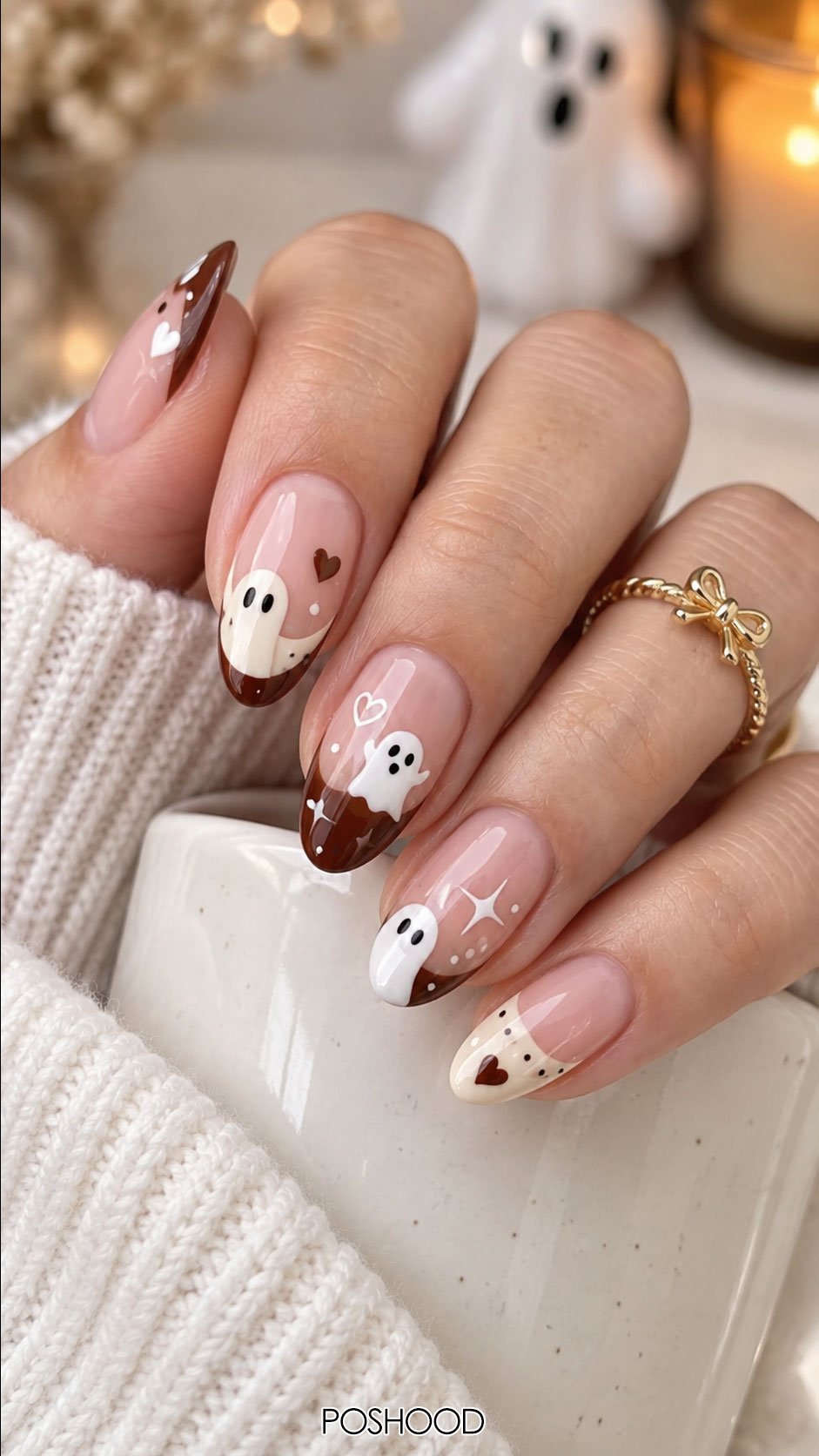 Cute Halloween nails ideas with brown and white French tips, adorable ghost nail art, heart accents, and glossy almond nails.