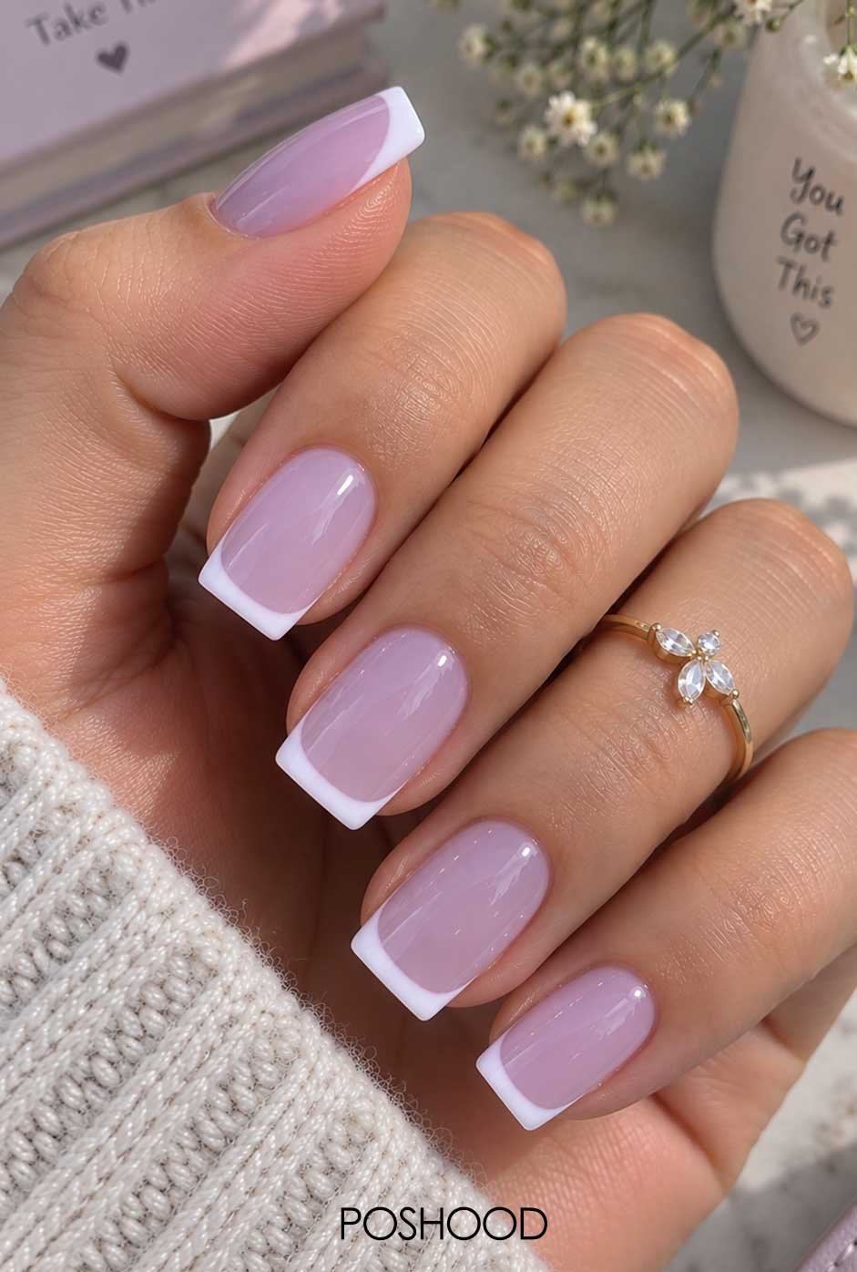 Glossy pastel lavender nails with clean white French tips on a hand wearing a floral ring